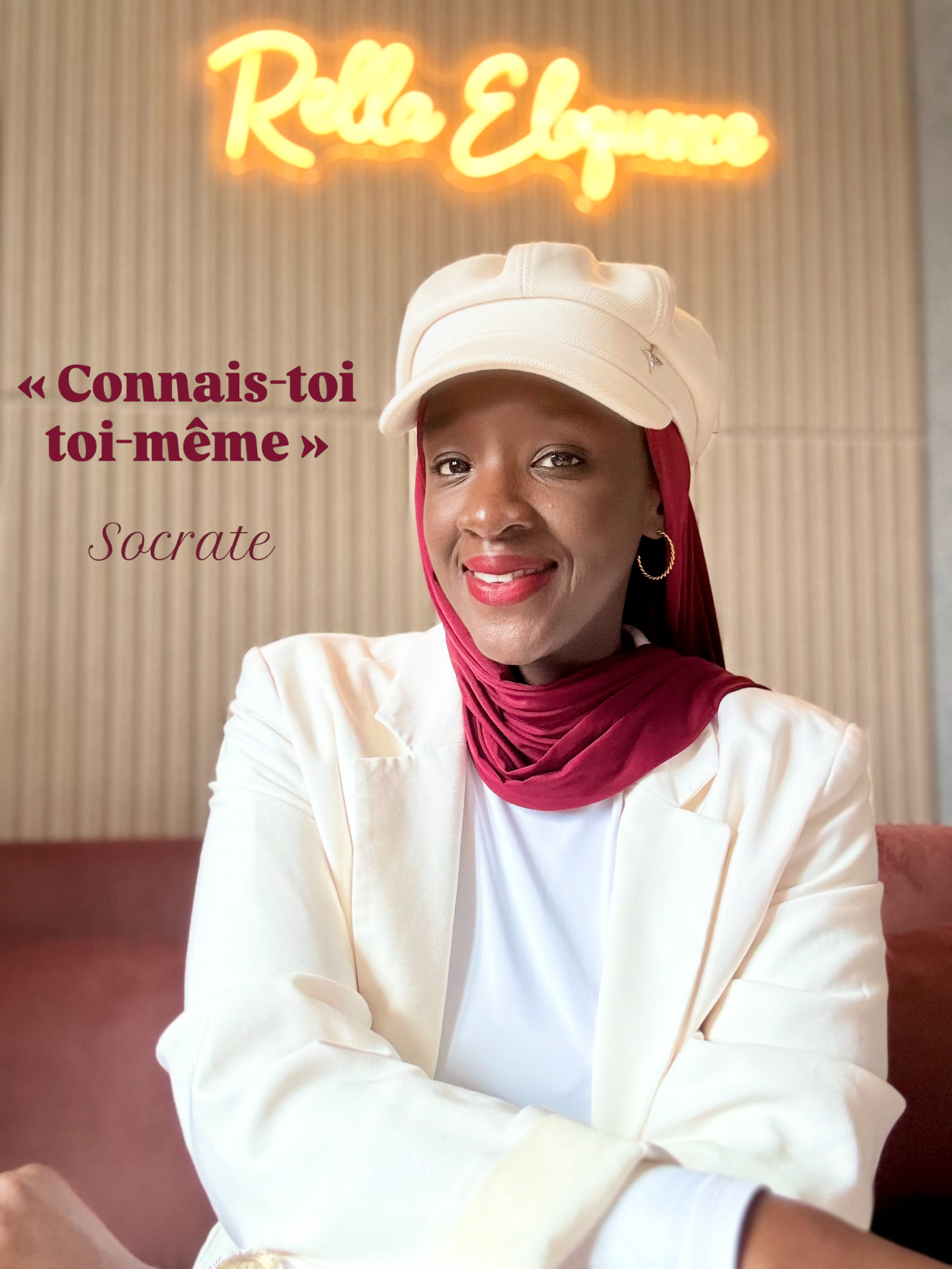 Mariame souriante devant l'enseigne lumineuse Rella Éloquence — « Connais-toi toi-même », Socrate